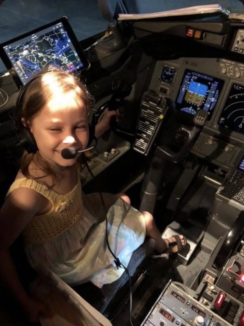 Young girl wearing a headset in an airliner cockpit