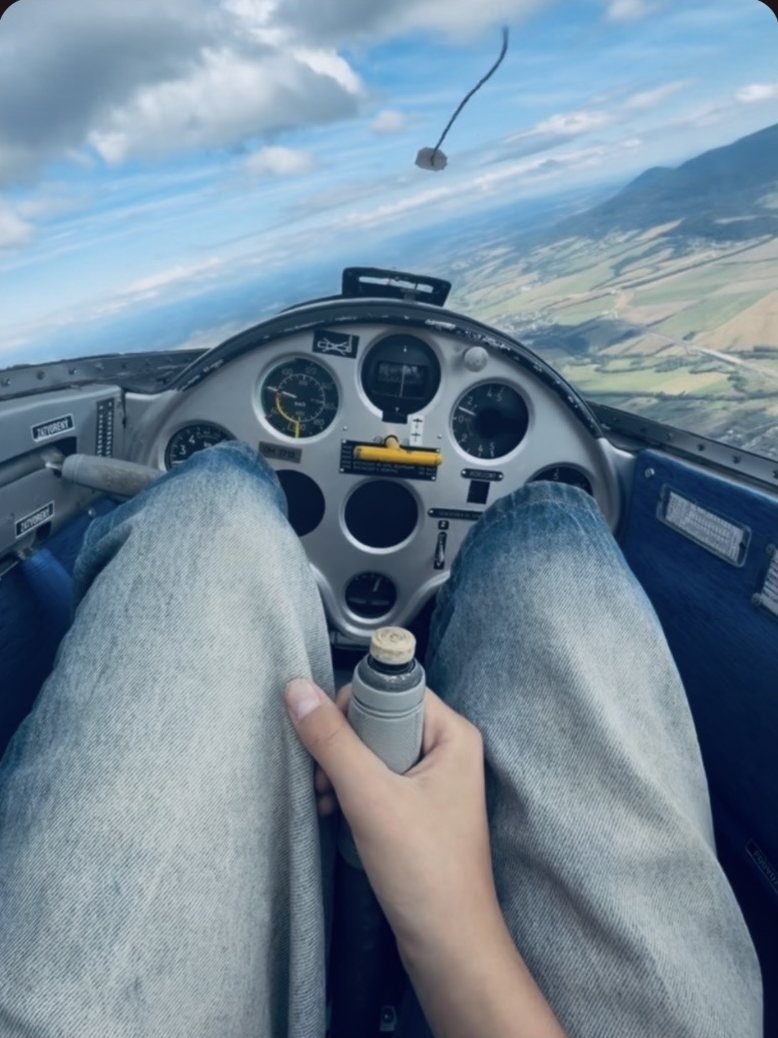 View over a pilot’s lap to the instrument panel of a glider in flight